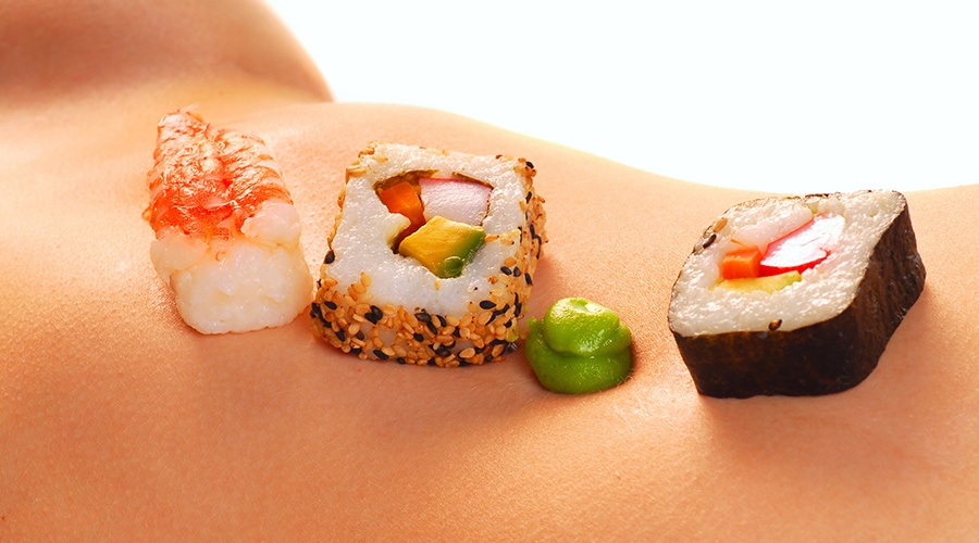 kilka kawałków sushi na nagim ciele modela body sushi w apartamencie