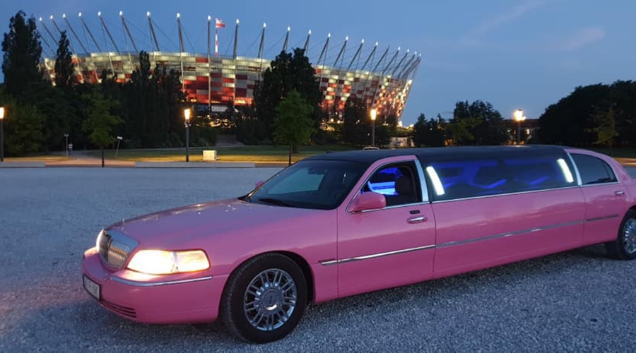 piękna różowa limuzyna po zmroku czeka na wieczór panieński pod blokiem