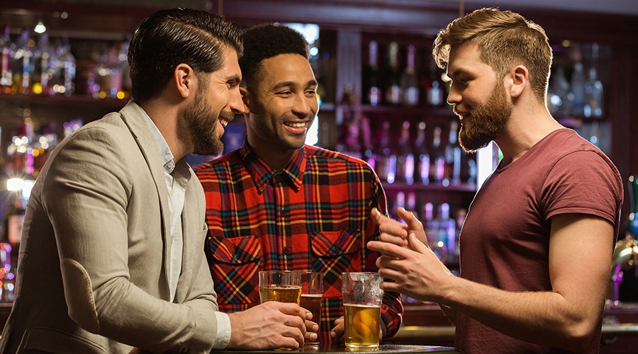 trzech kawalerów przy barze na kawalerskim bawią się w klubie i świętują wieczór