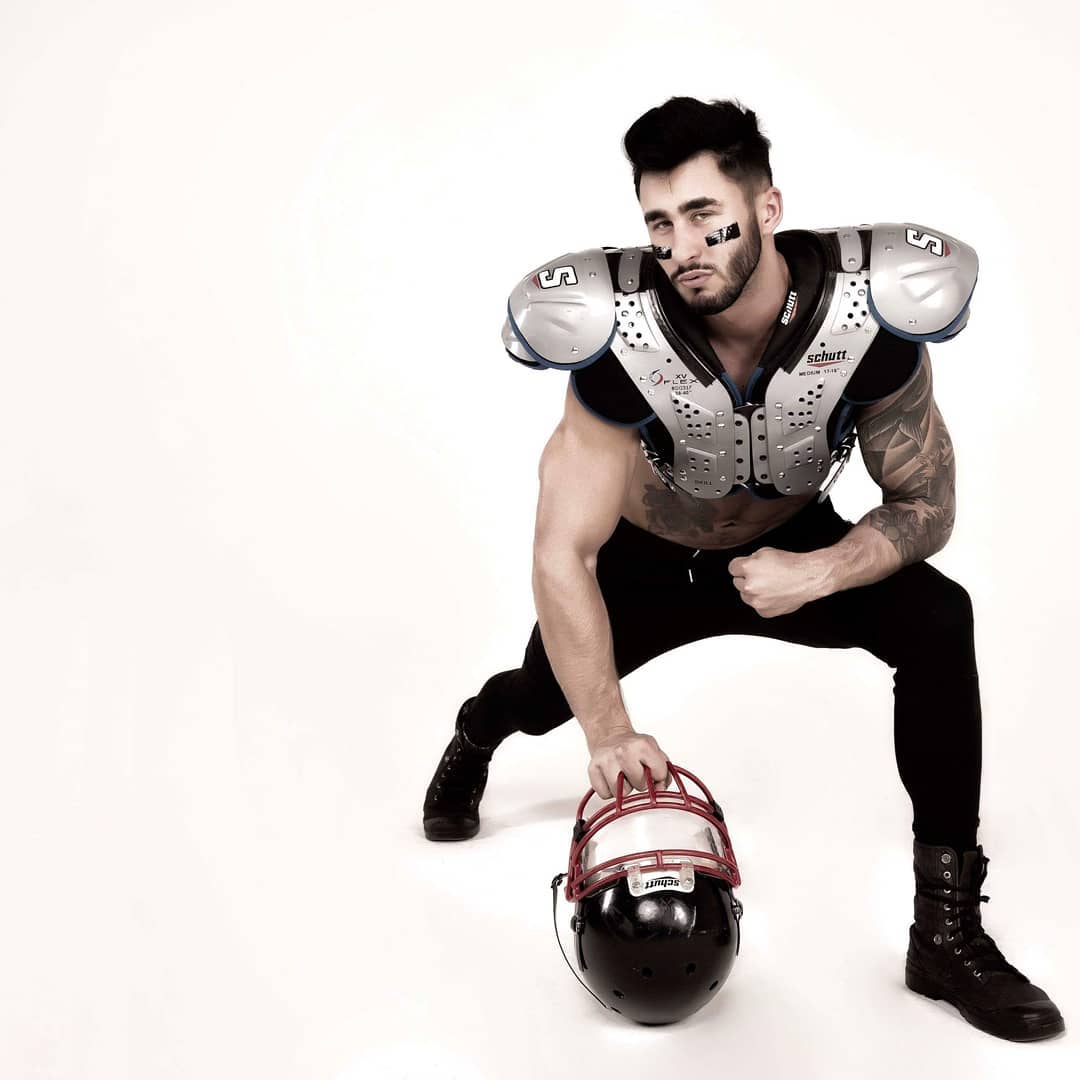 tancerz erotyczny w stroju footboolisty w okunince nad jeziorem